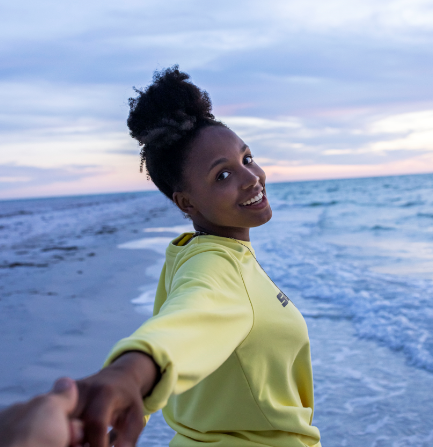 girl on beach turning around with a smile. 